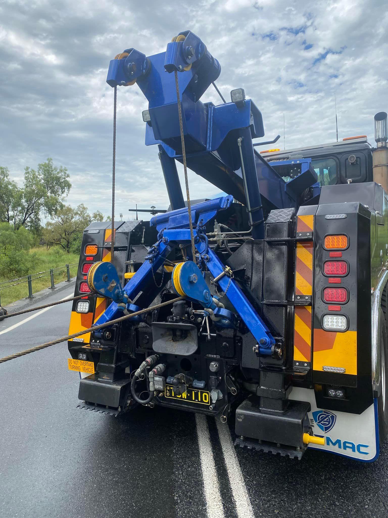 Rear View of a Blue and Black Tow Truck Parked on a Road With a Cloudy Sky — Fitzroy Towing & Transport in Gladstone, QLD