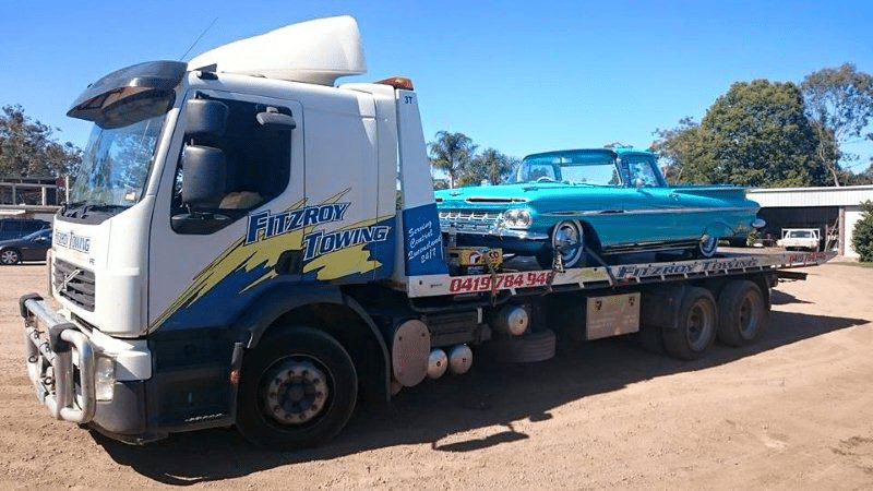 A Blue Classic Car is Being Towed by a White Fitzroy Towing Truck on a Sunny Day — Fitzroy Towing & Transport in Biloela, QLD