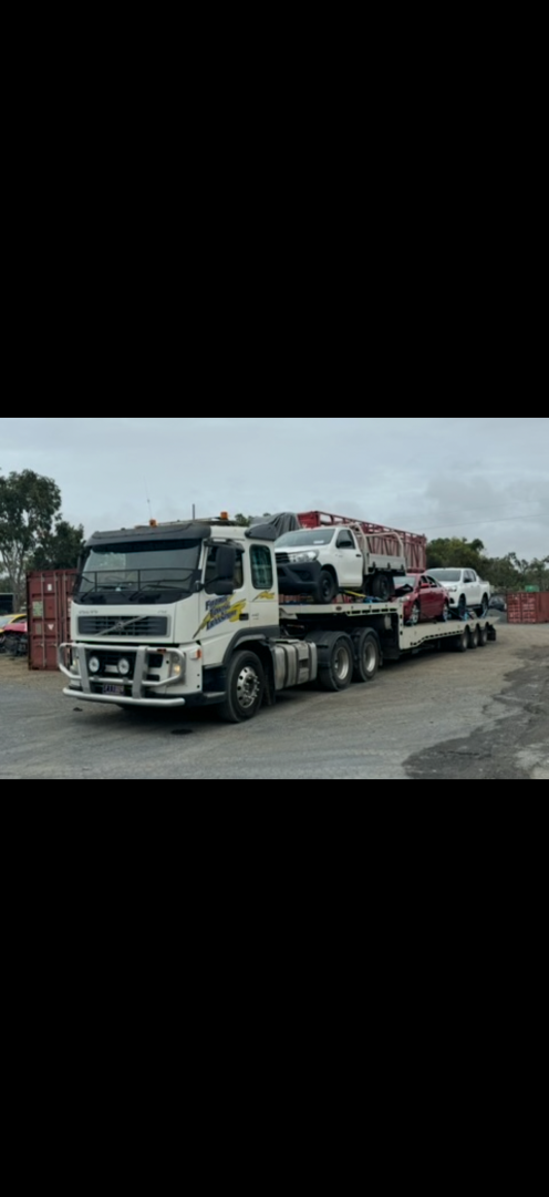 A car carrier truck transporting vehicles on a cloudy day.— Fitzroy Towing & Transport in Parkhurst, QLD