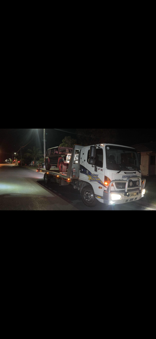 White truck with headlights on at night— Fitzroy Towing & Transport in Parkhurst, QLD