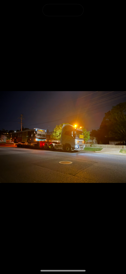 A semi-truck at night, lit by streetlights.