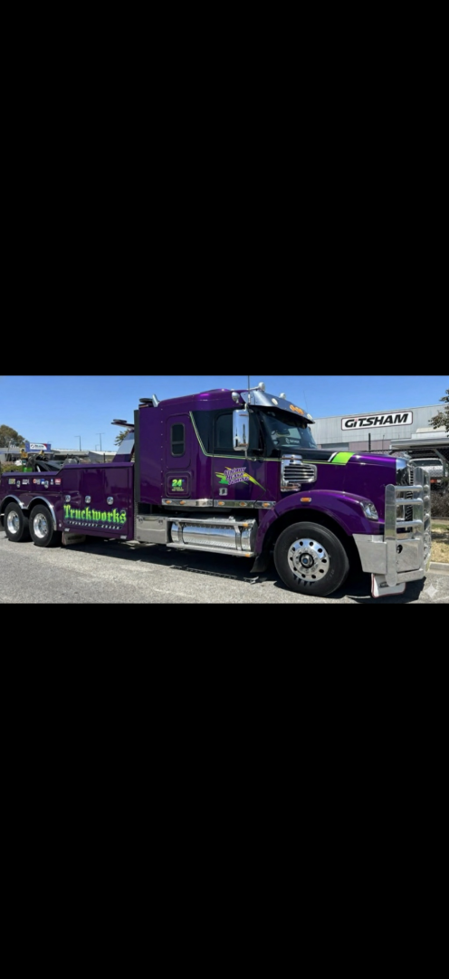 Purple tow truck parked outside.