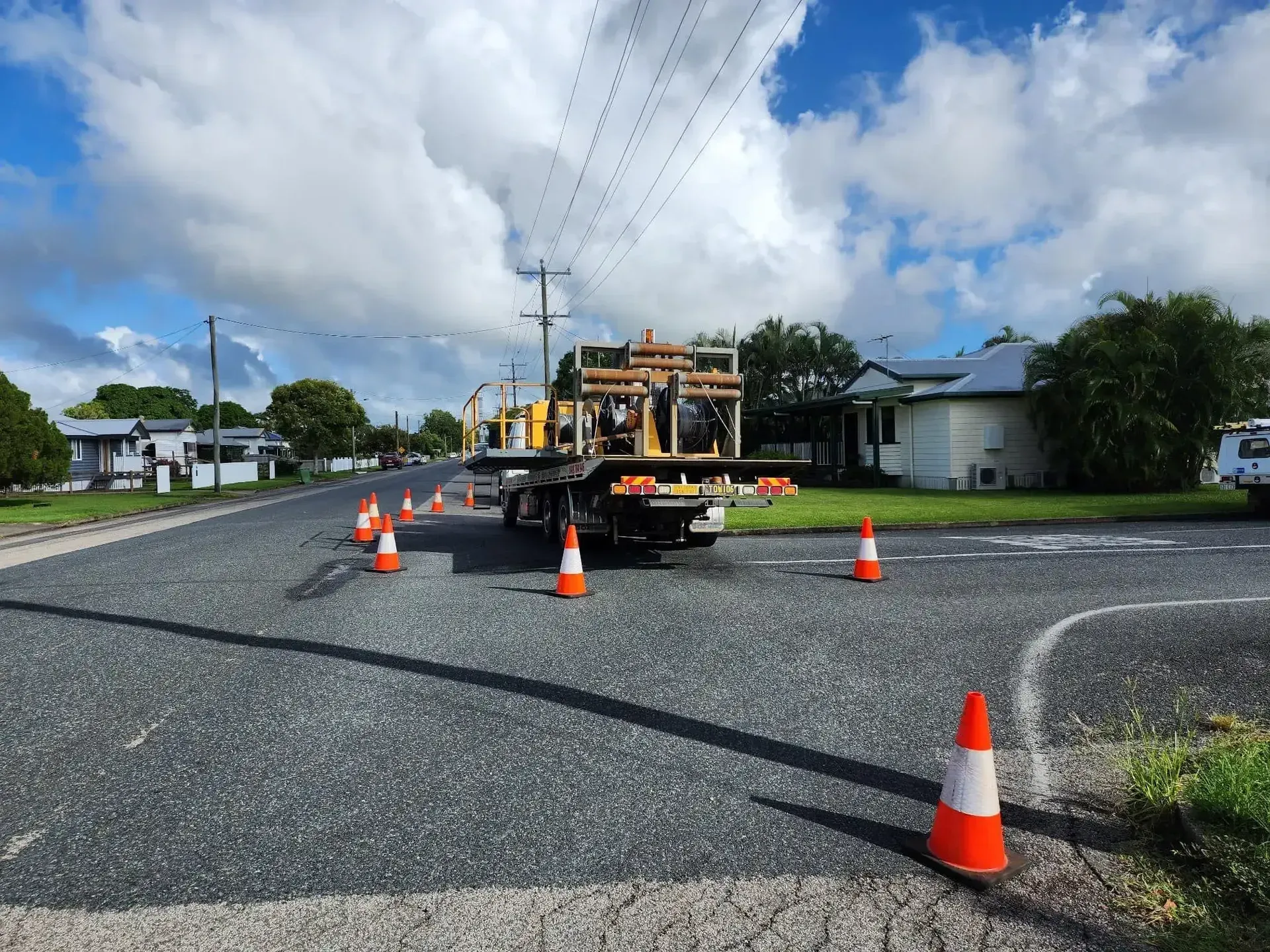 A Truck With a Utility Bed Surrounded by Orange Cones on a Street — Fitzroy Towing & Transport in Parkhurst, QLD