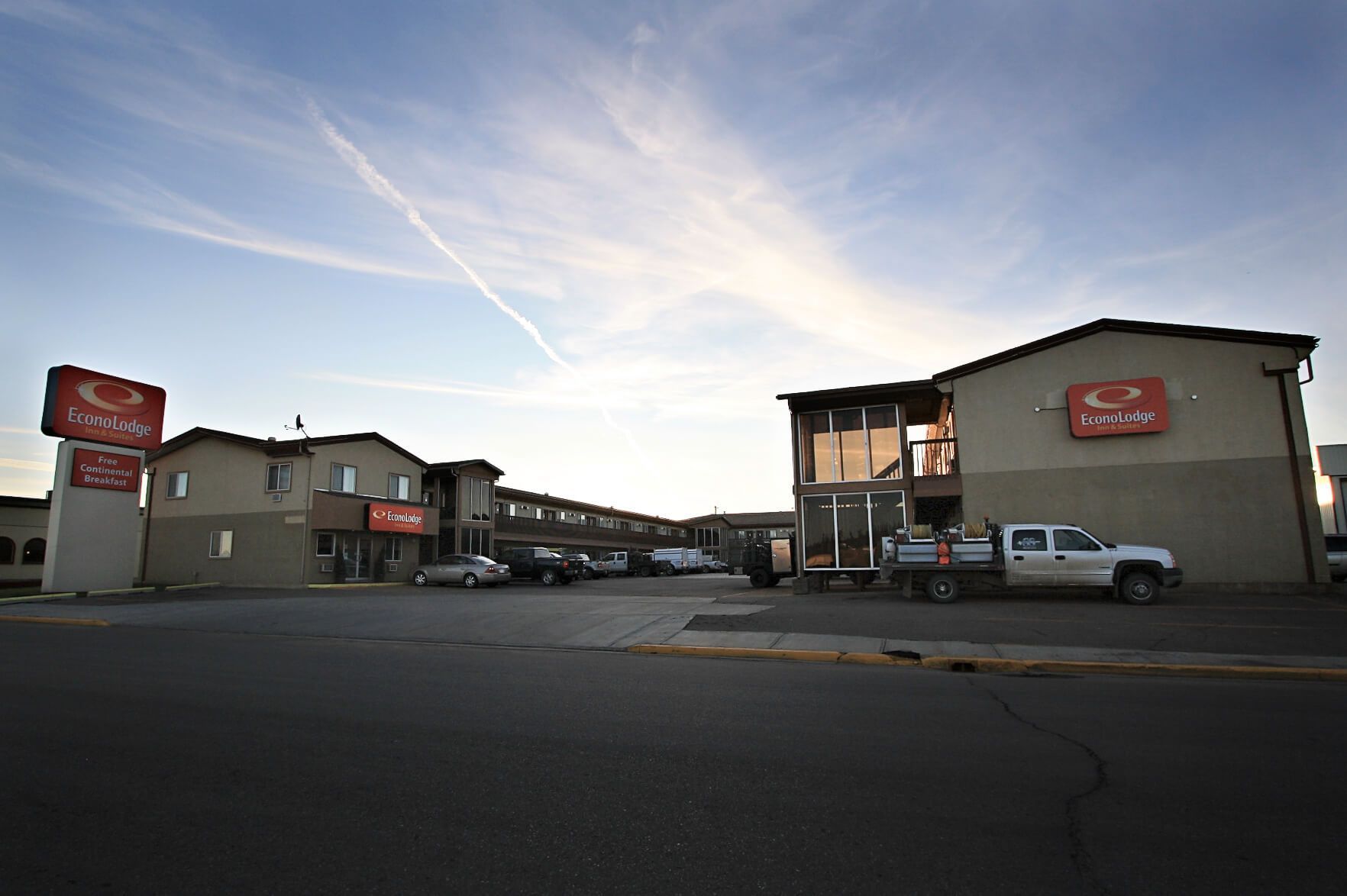 A white truck is parked in front of a motel