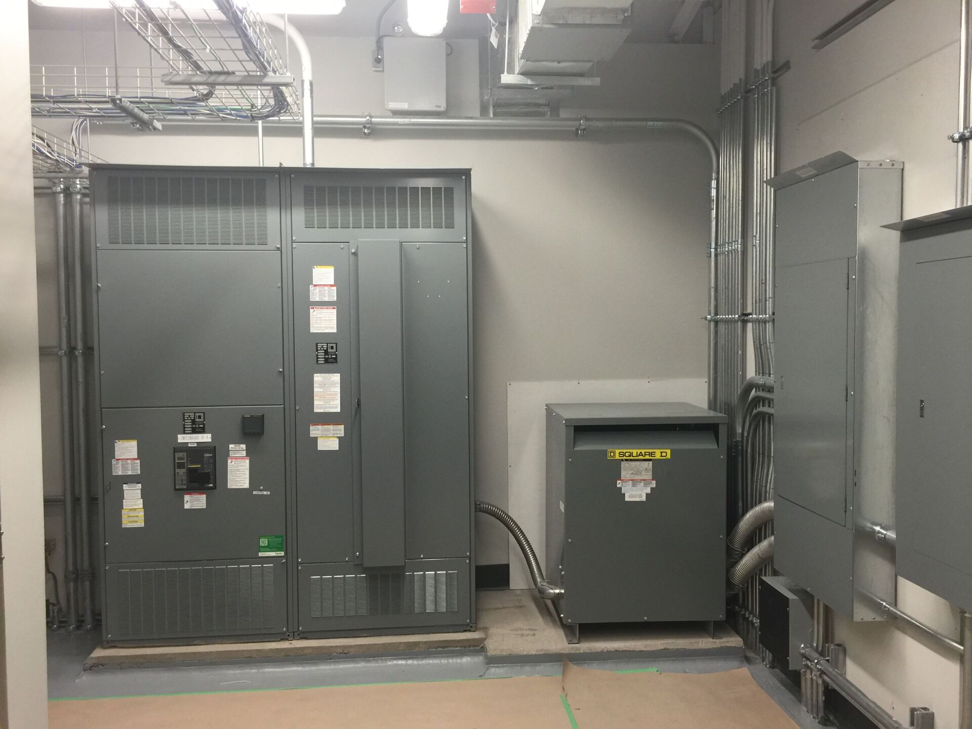 A room with a lot of electrical equipment including a transformer