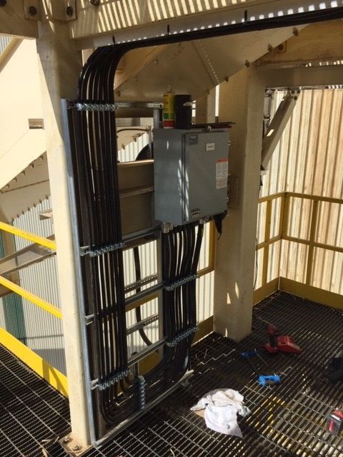 A staircase with a yellow railing and lots of wires