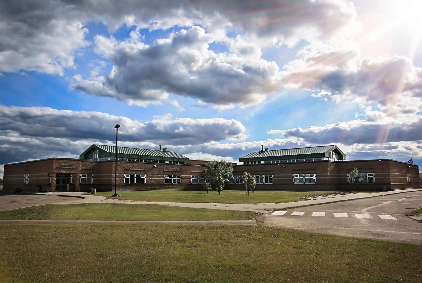 A large brick building with a cloudy sky in the background