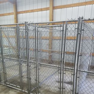 Chain link dog kennels inside a building.