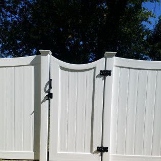White vinyl fence and gate with black hardware.