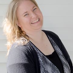 A sparkly woman is smiling and wearing a black and white sweater.