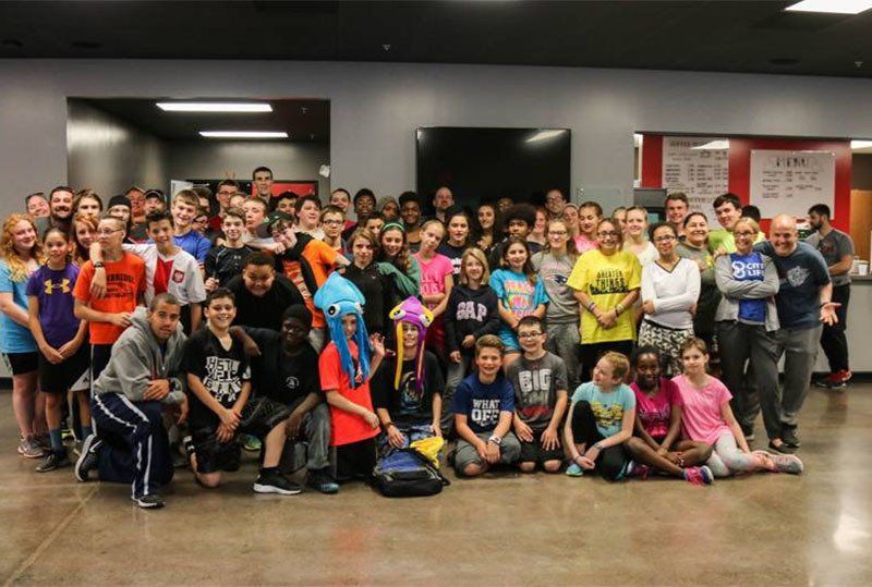 A large group of people are posing for a picture in a room.