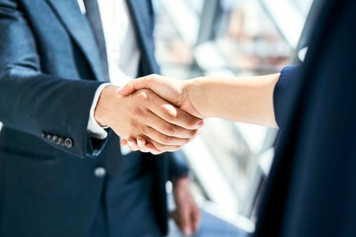 Un uomo e una donna si stringono la mano in un ufficio.