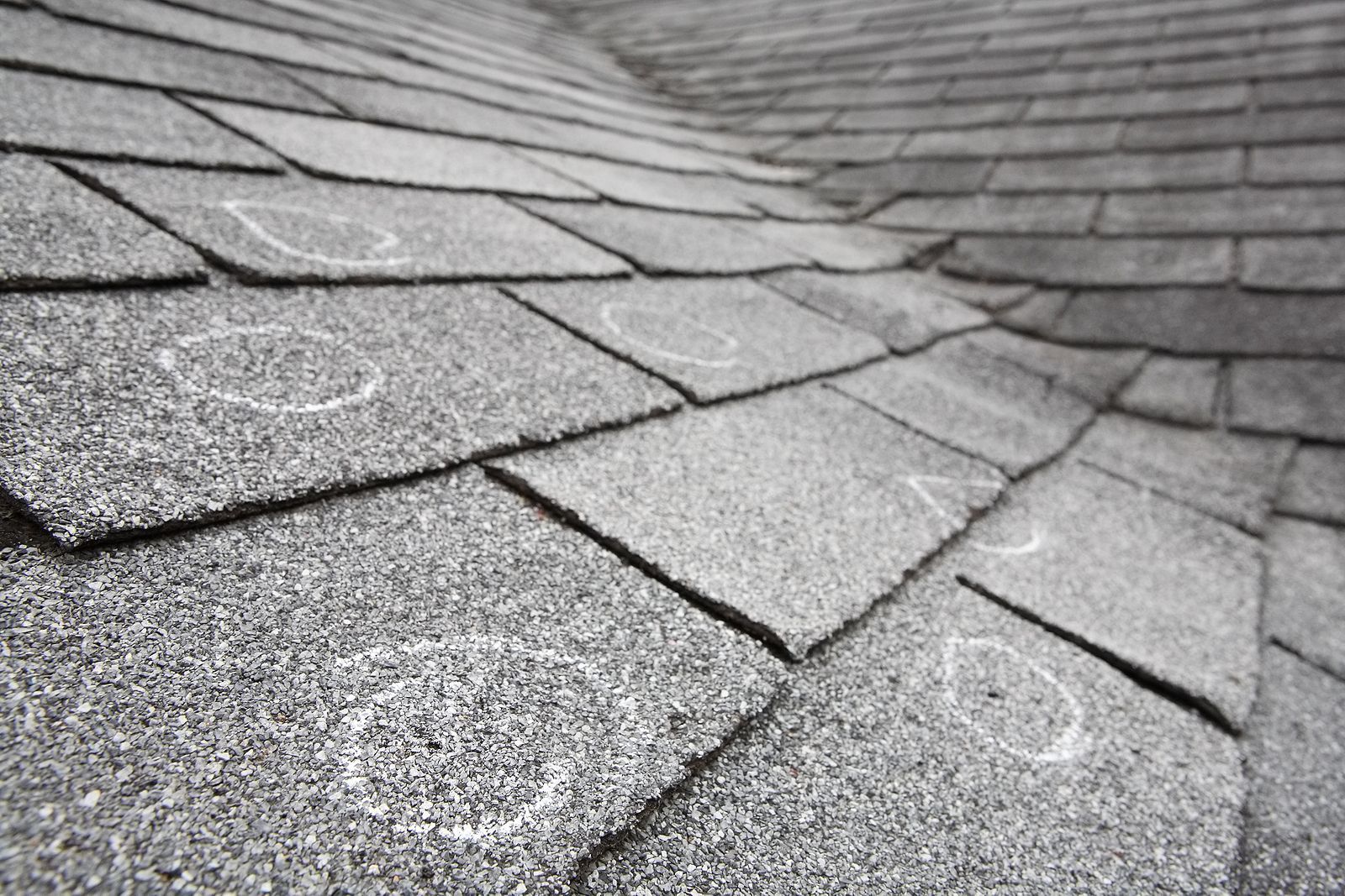 A black and white photo of a roof with hail damage.