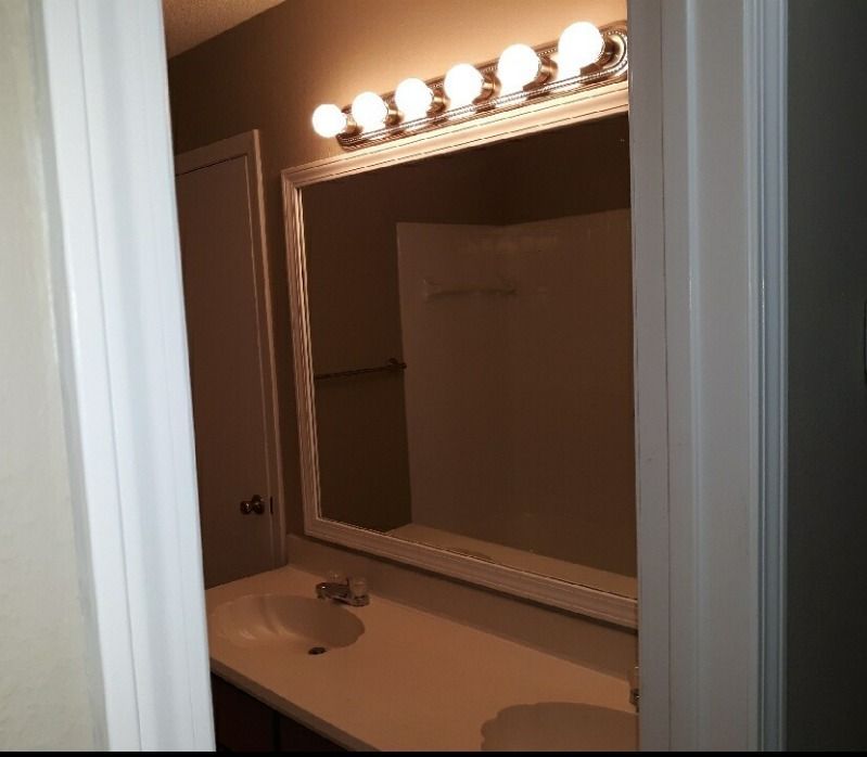 a bathroom with a large mirror and a sink