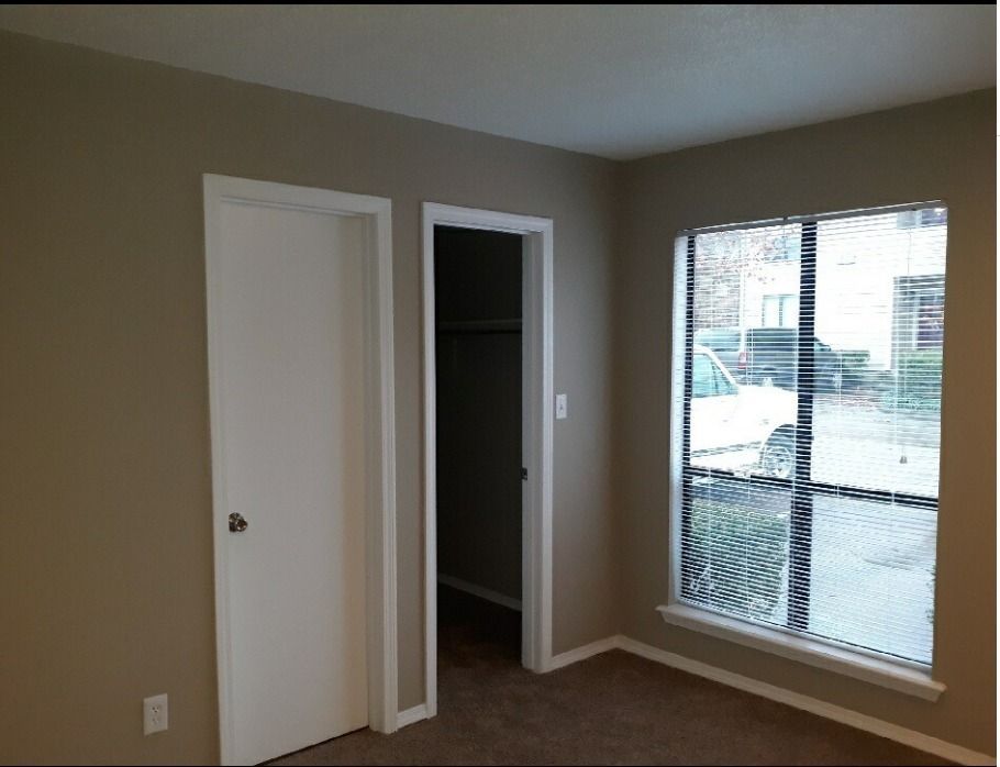 an empty room with a window and a door