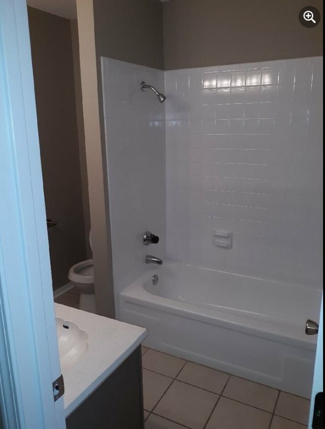 a bathroom with a tub , sink , toilet and shower .