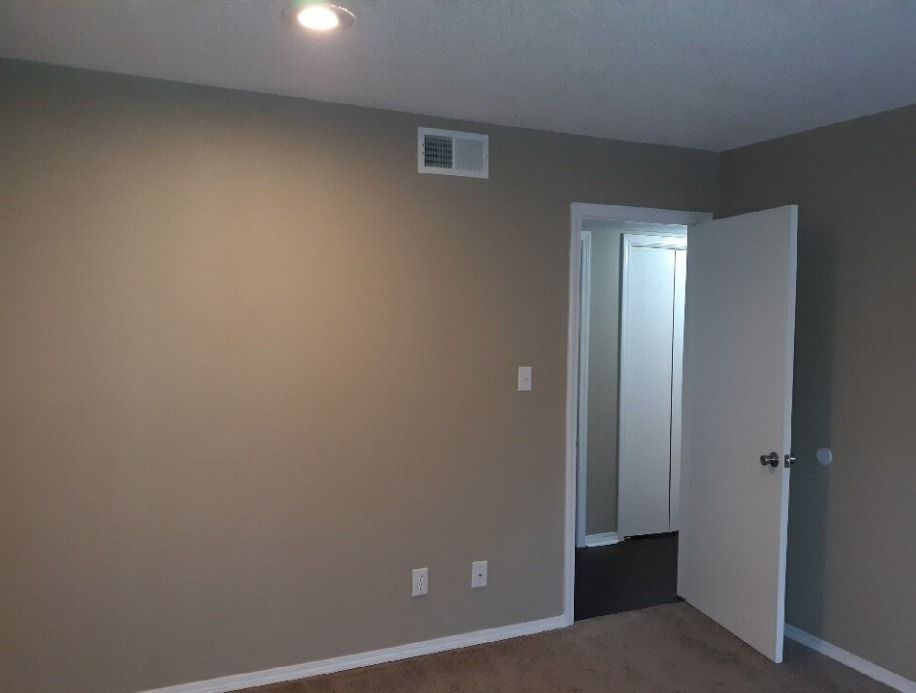 an empty bedroom with a door open to a bathroom .