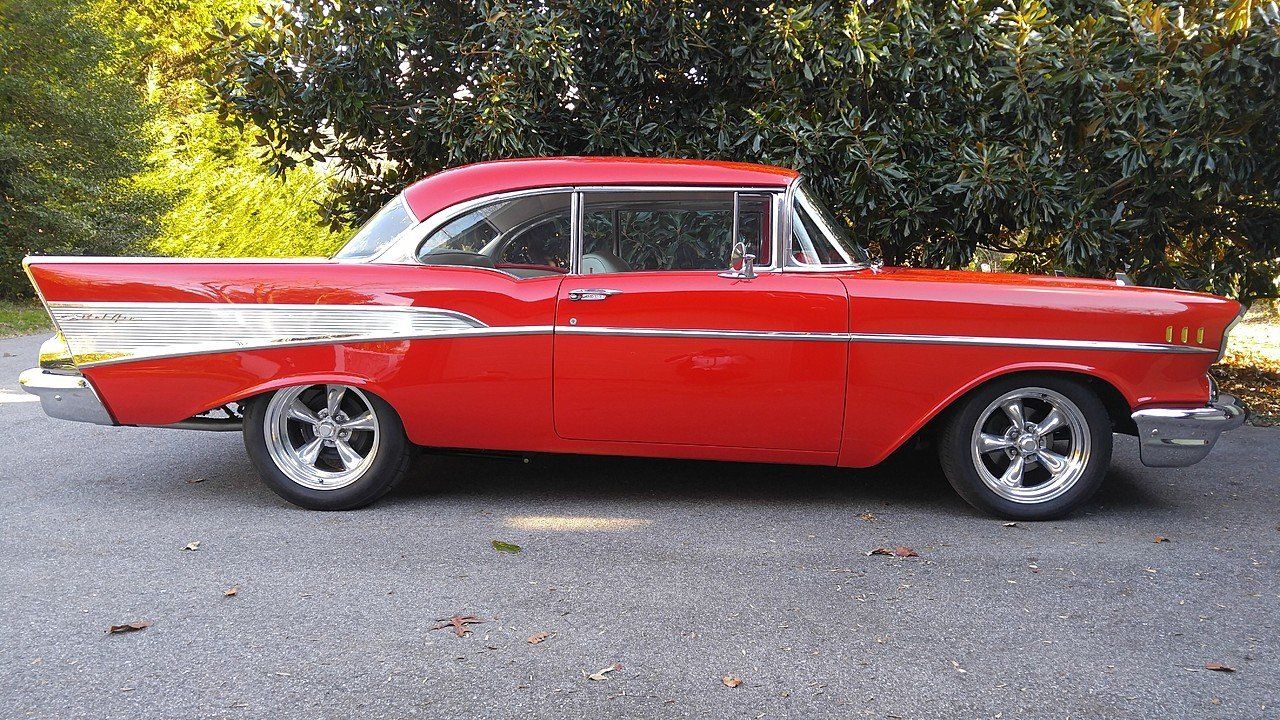 A red car is parked on the side of the road.