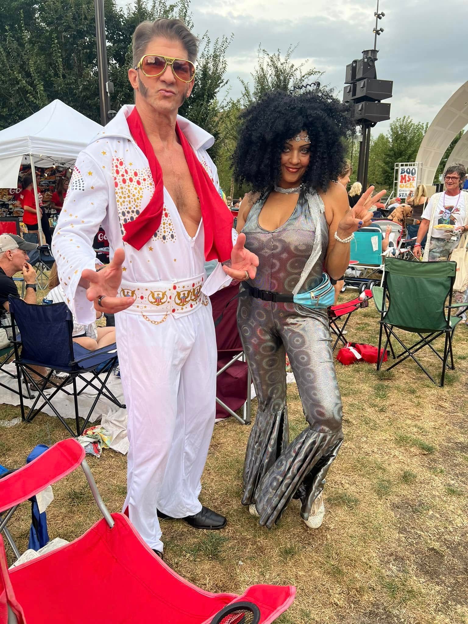 A man and a woman in elvis presley costumes are standing next to each other