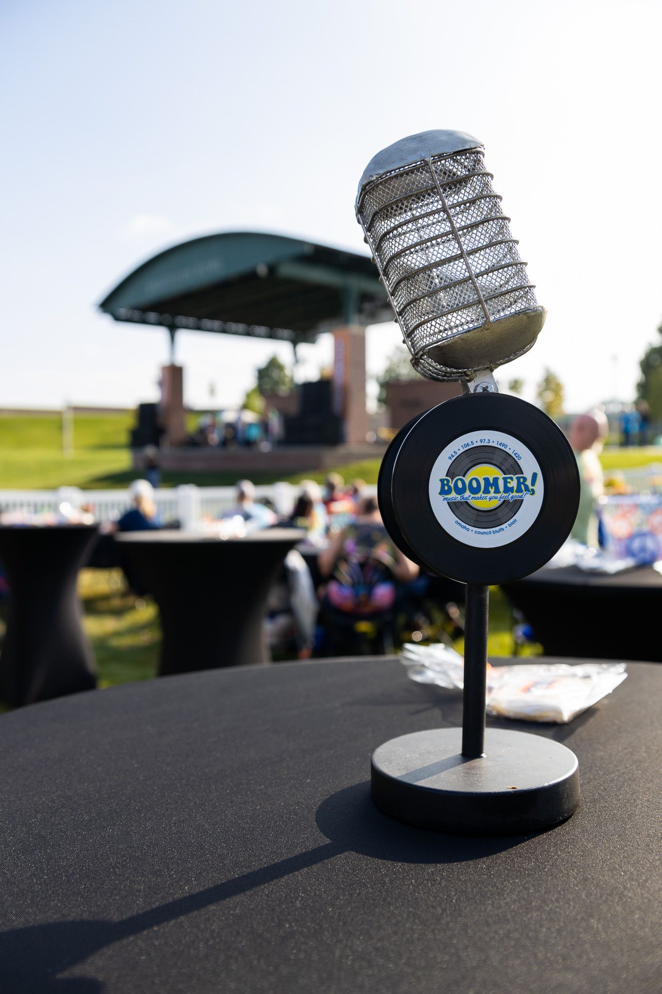 A microphone on a table with a sign that says Boomer Radio on it