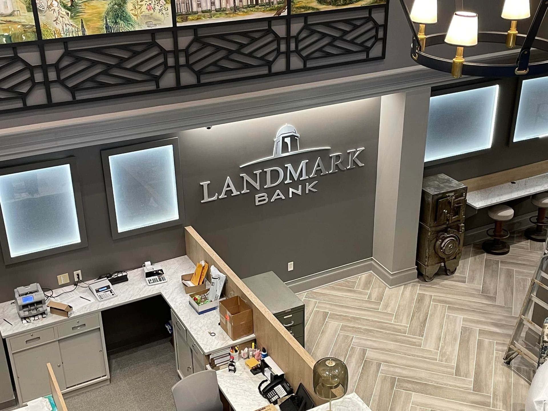Overhead view of Landmark Bank interior with gray walls, bank logo, and employee workstations.