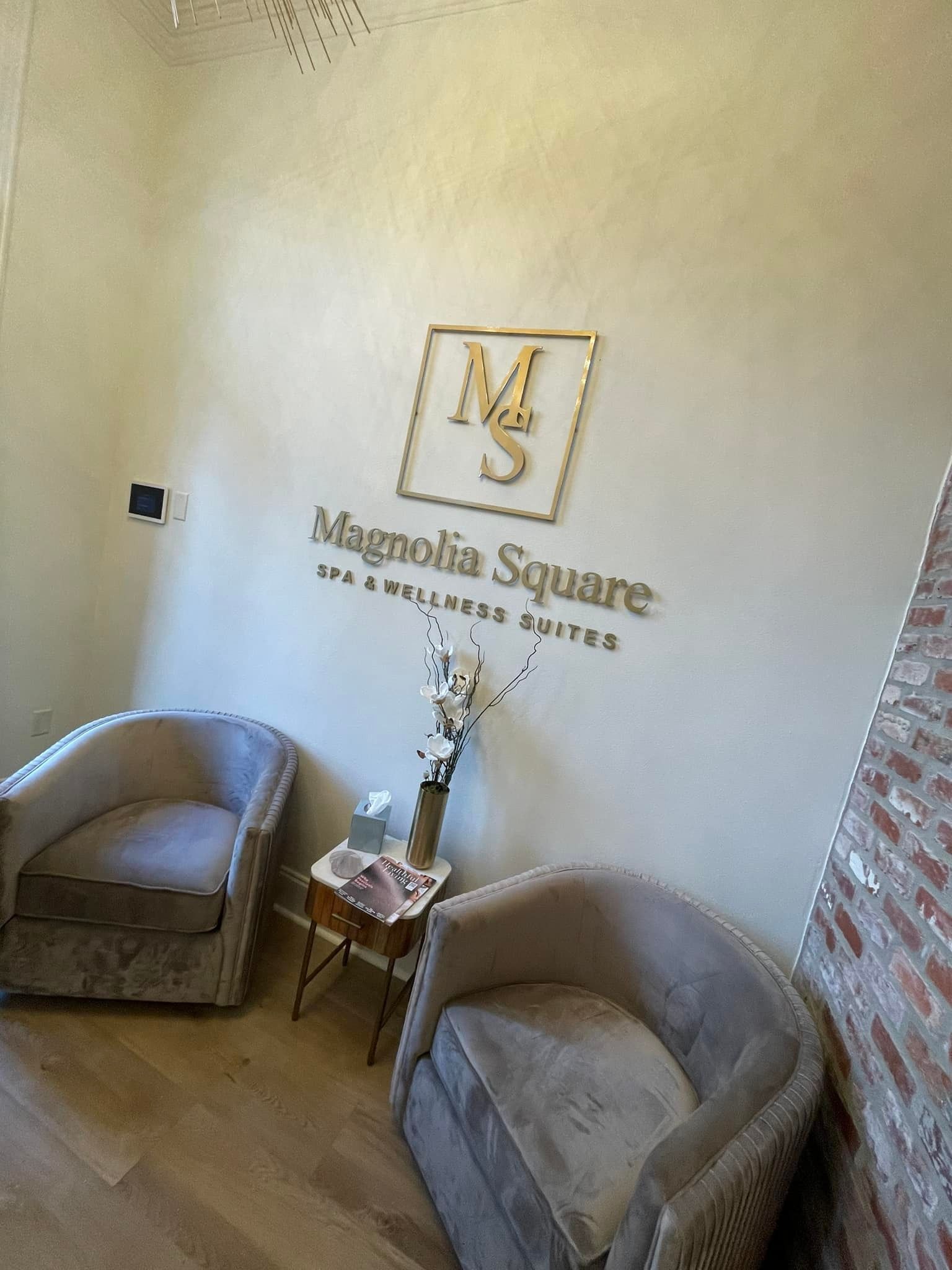 Two gray chairs in a waiting area with gold 