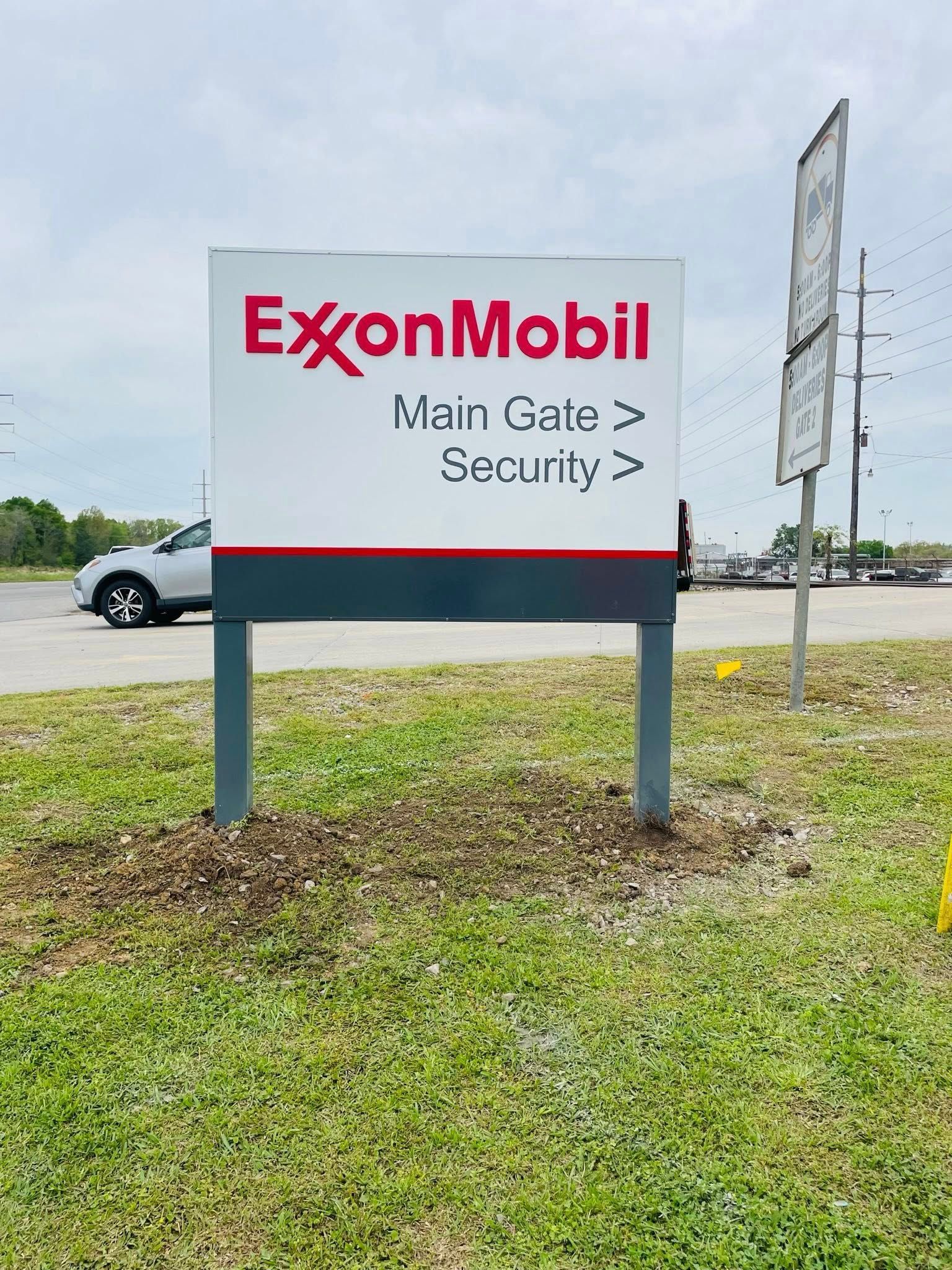 Sign for ExxonMobil, red and white logo, directions to main gate and security.