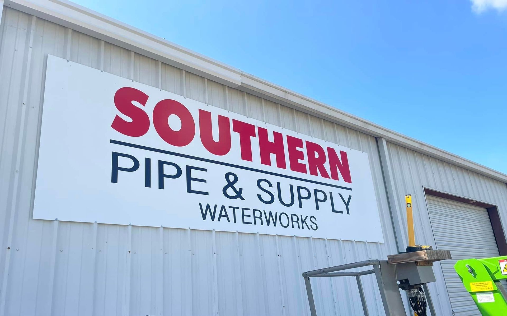 Sign for Southern Pipe & Supply Waterworks; white building with red and black text against a blue sky.