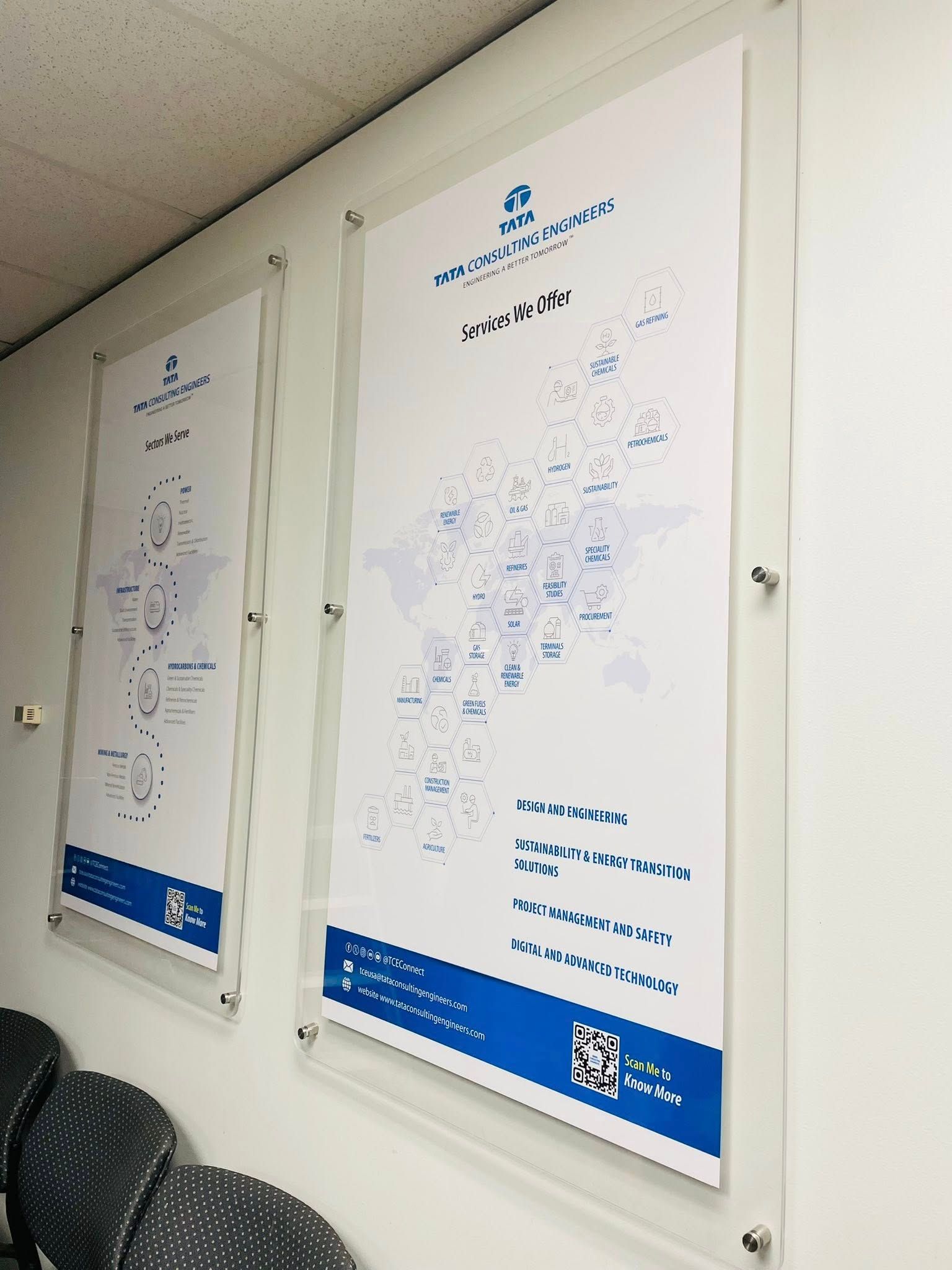 Two posters mounted on a wall with maps and company information in blue and white.
