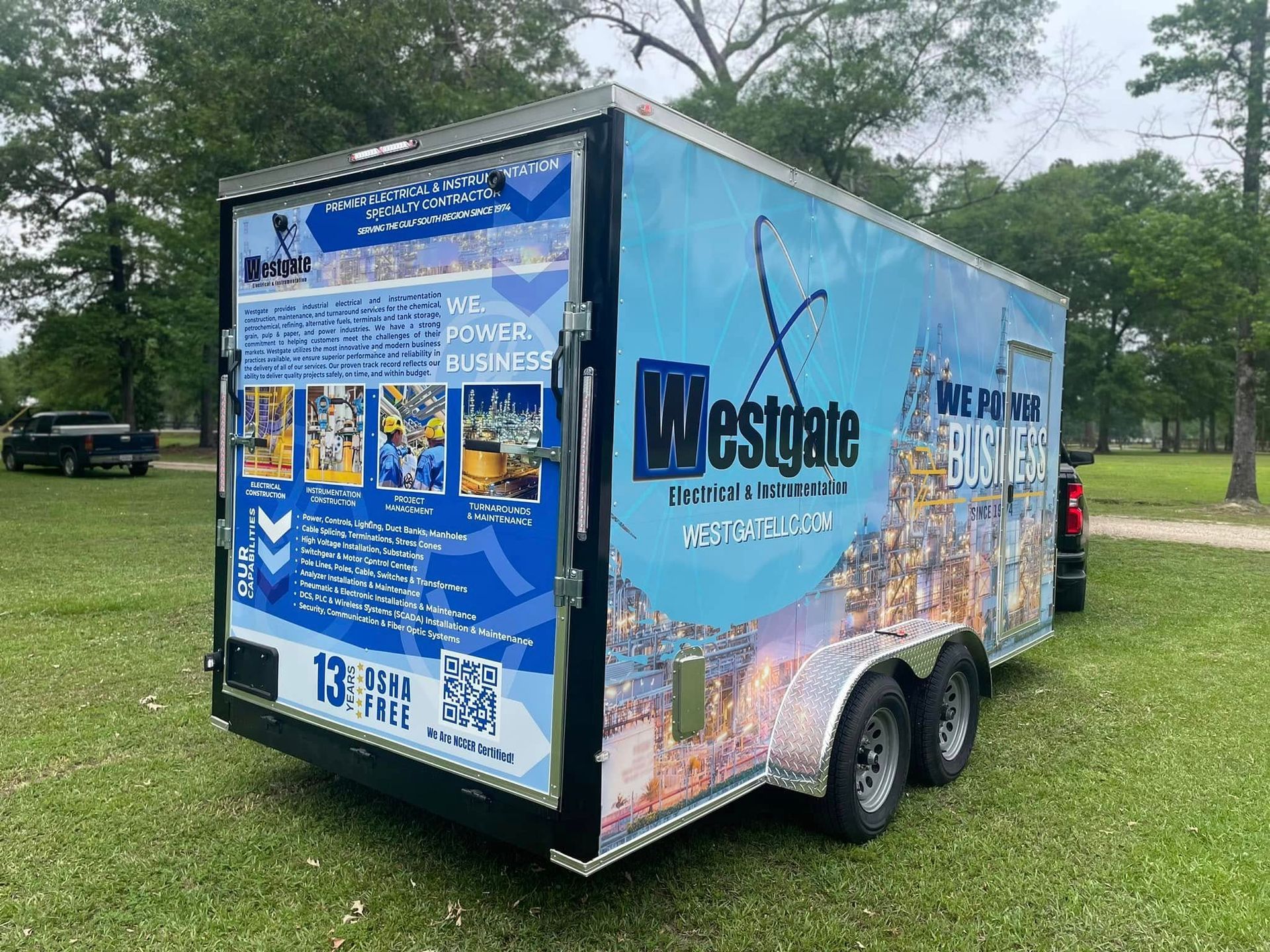 Blue and white trailer with Westgate logo parked on grass.