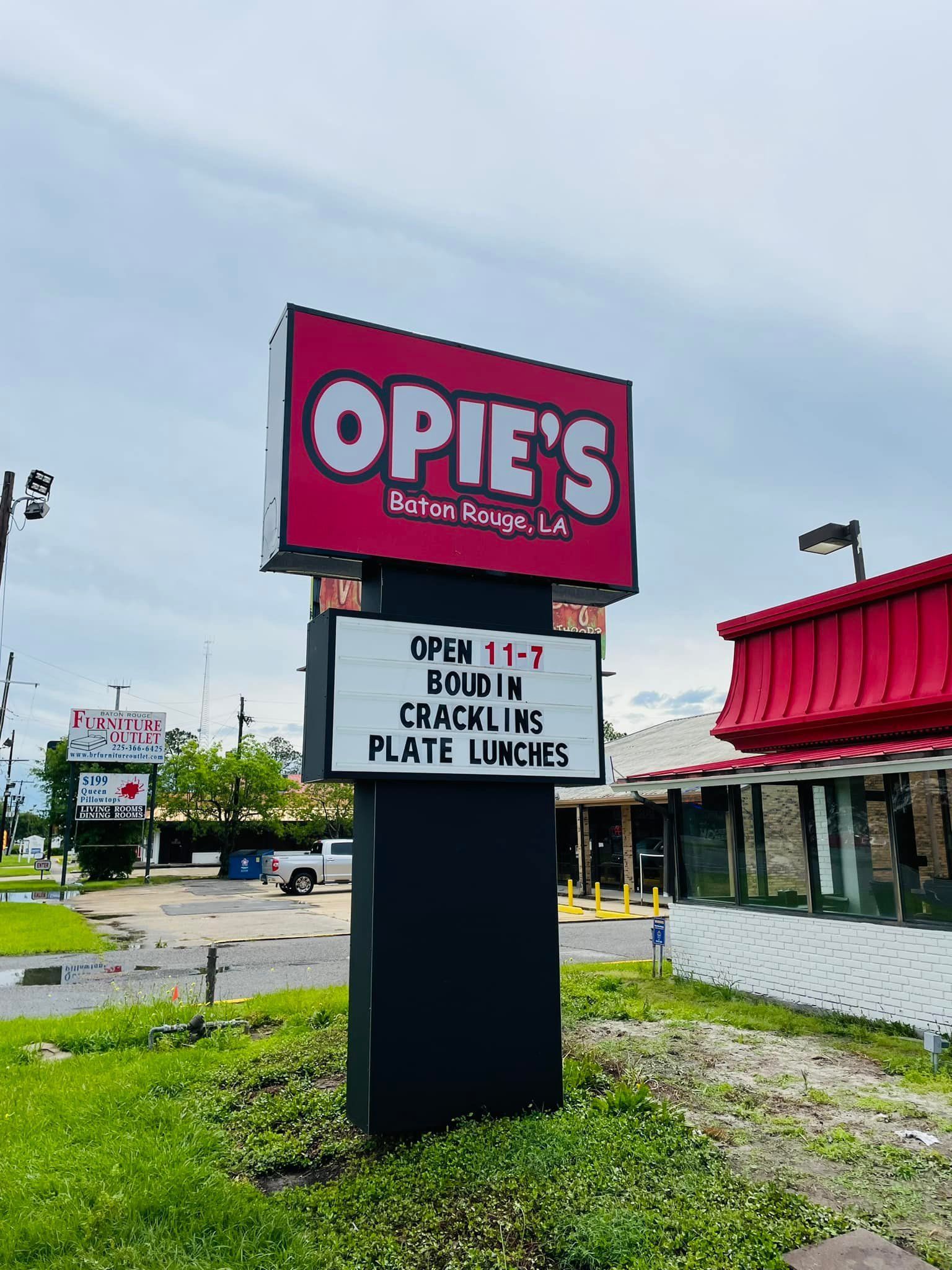 Sign for Opie's Cajun Restaurant; red sign on black post, text 