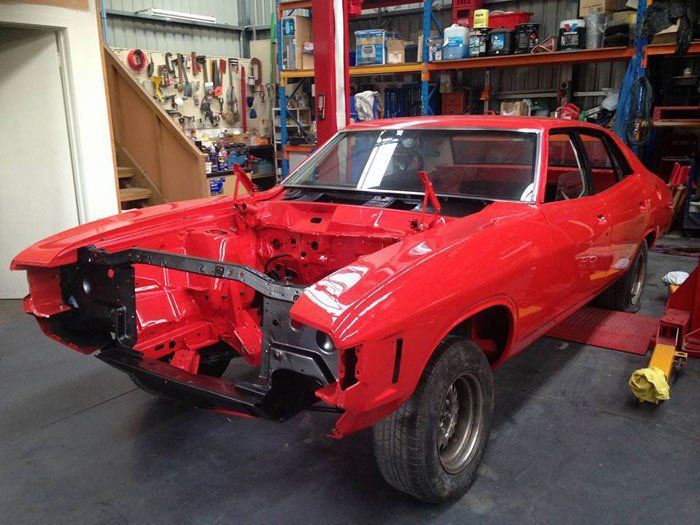 View of a red car during repair