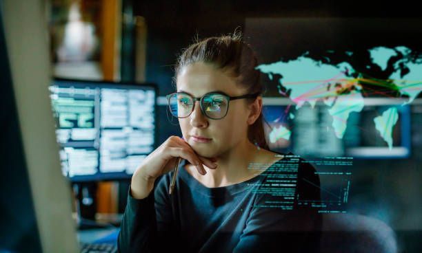 A woman wearing glasses is looking at a computer screen.