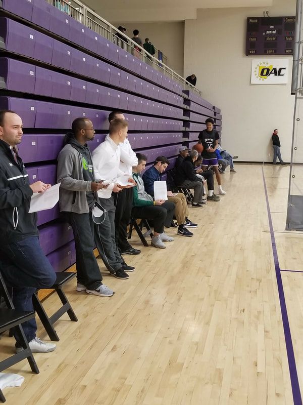 A group of people sitting in bleachers watching a basketball game