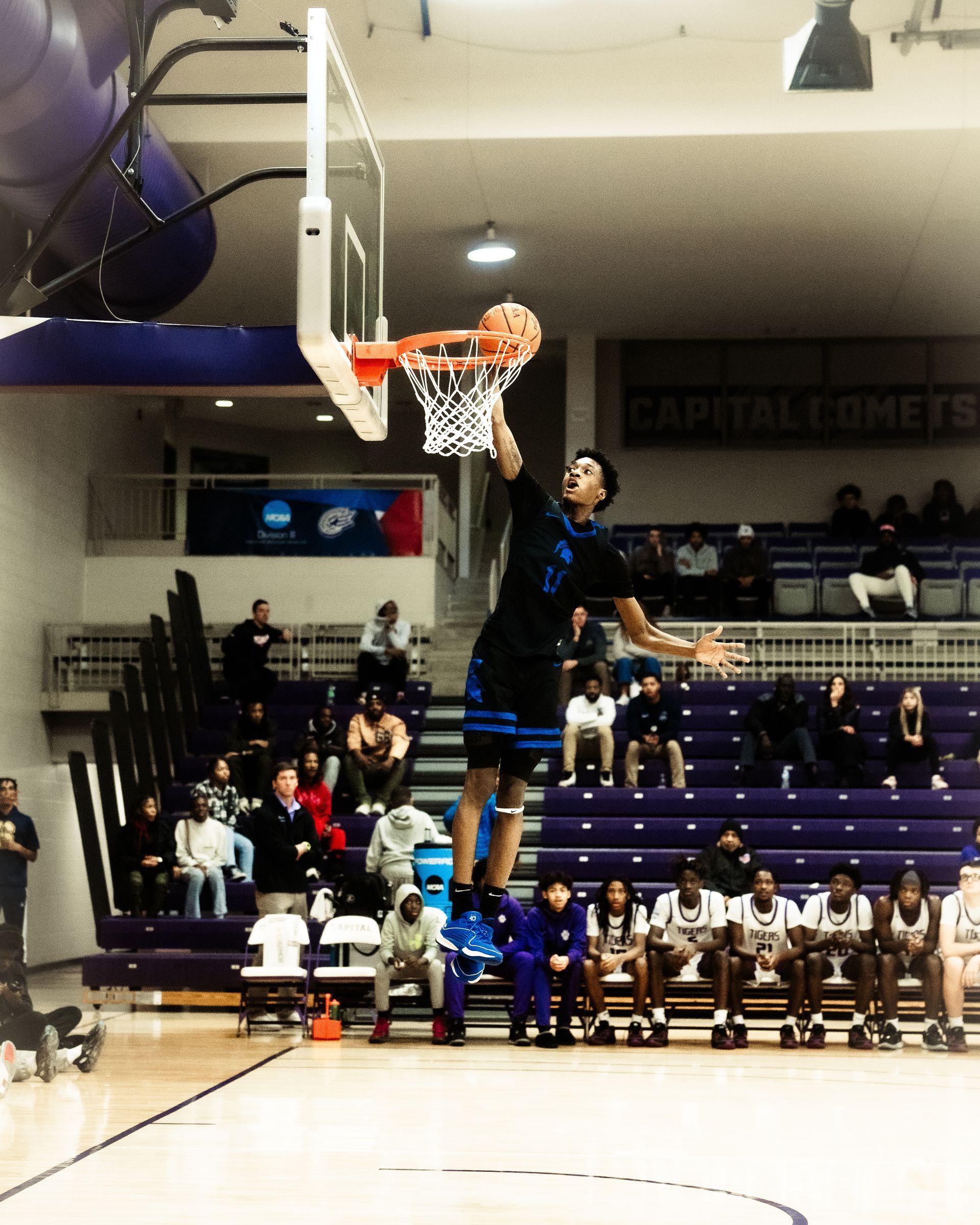 A basketball player jumps in the air to dunk the ball