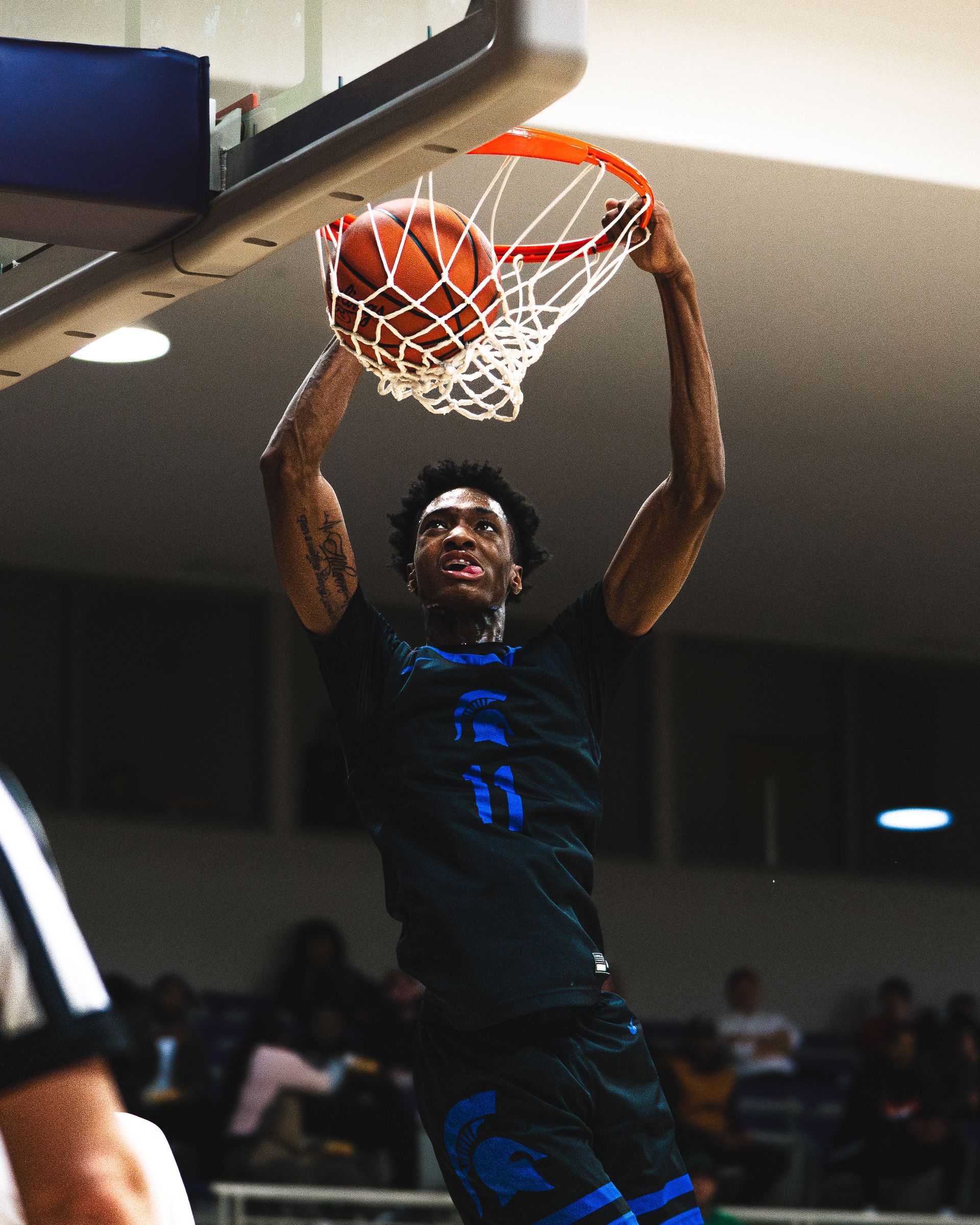 A basketball player is dunking a basketball into the net