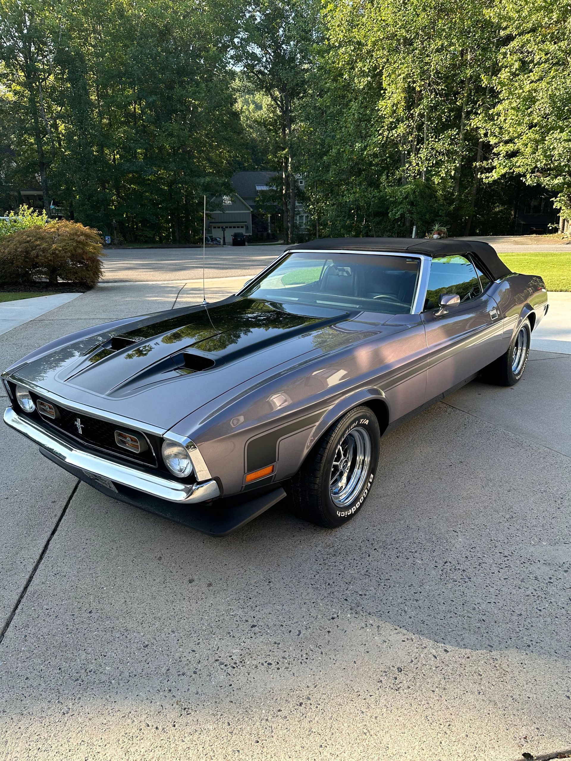 Gray convertible Ford Mustang Mach 1 parked on a paved driveway with black hood scoop.