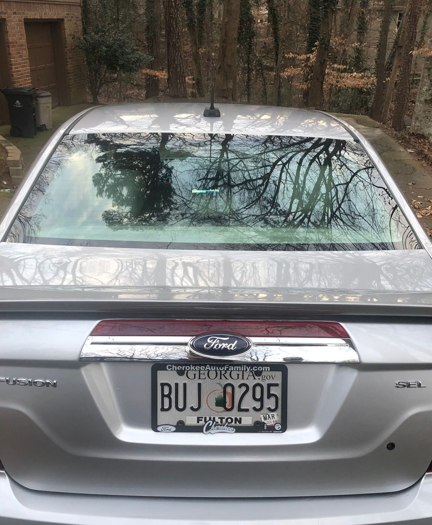 Rear view of a silver Ford sedan with a license plate from Payton.