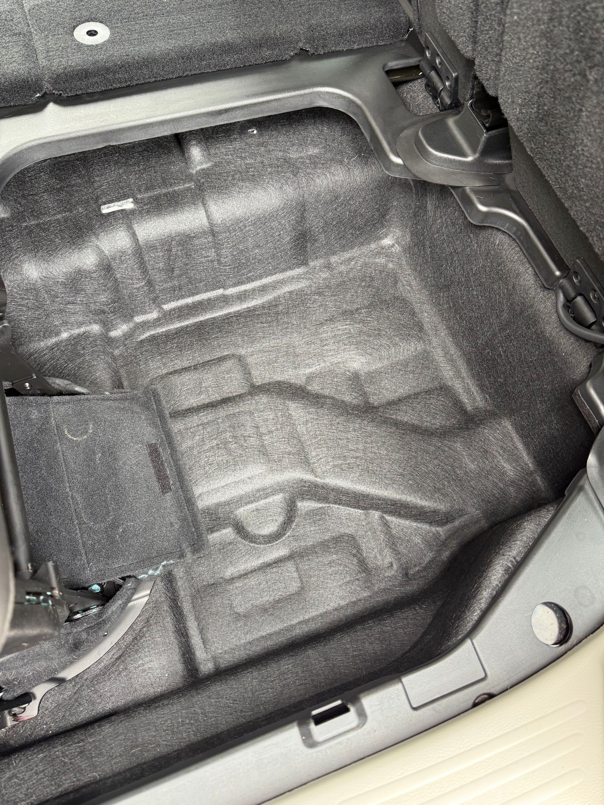 Dark gray interior car compartment with textured floor.