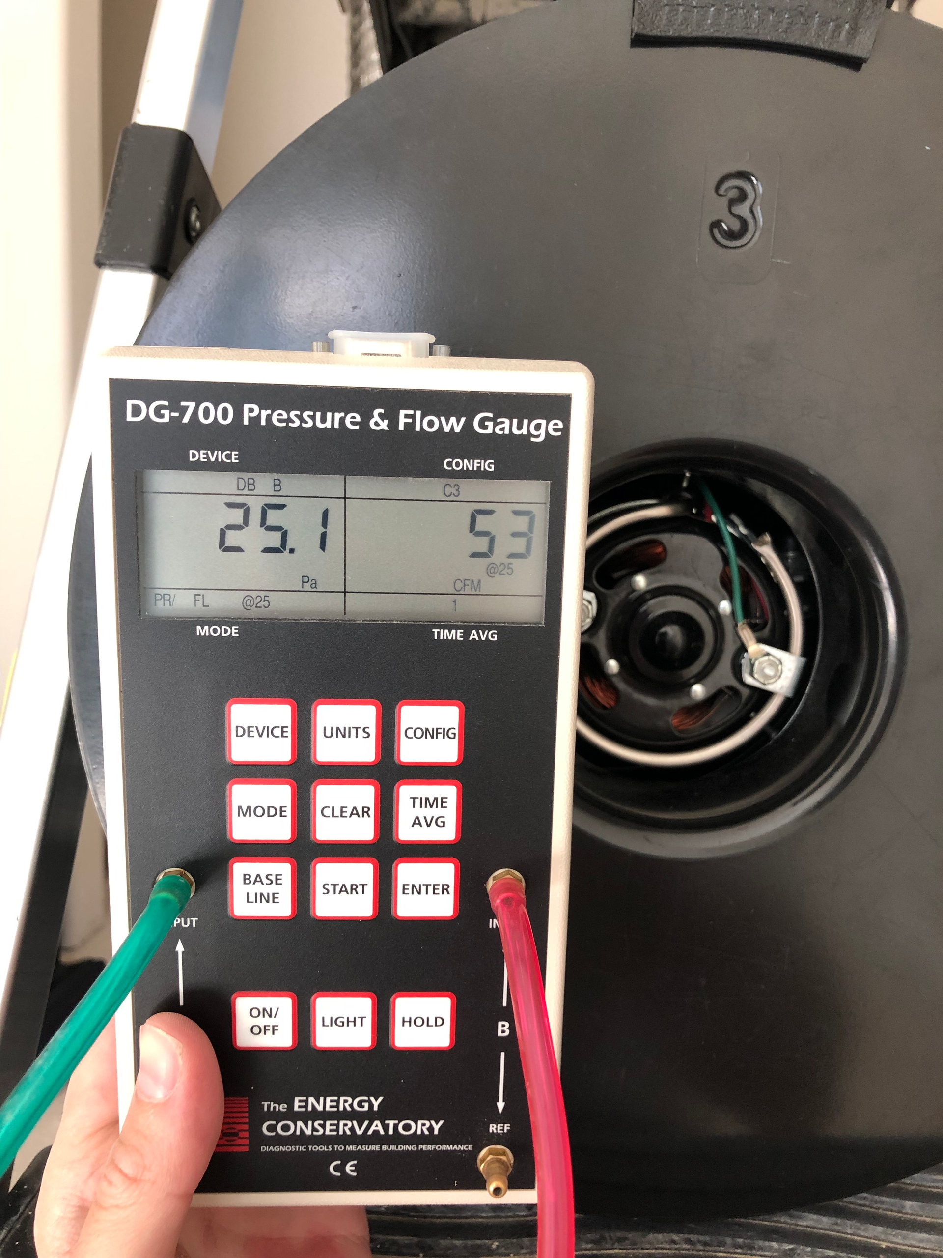 A person holding a pressure and flow gauge device
