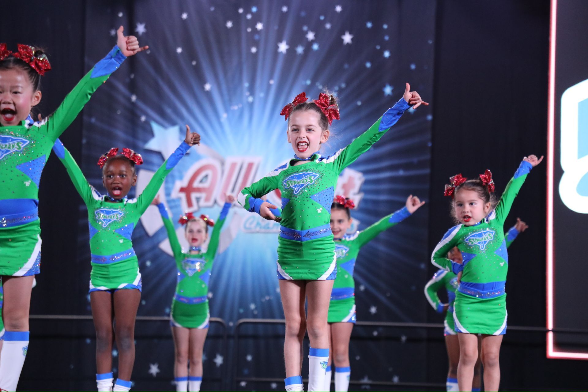 A group of cheerleaders are performing in front of a sign that says national leaders
