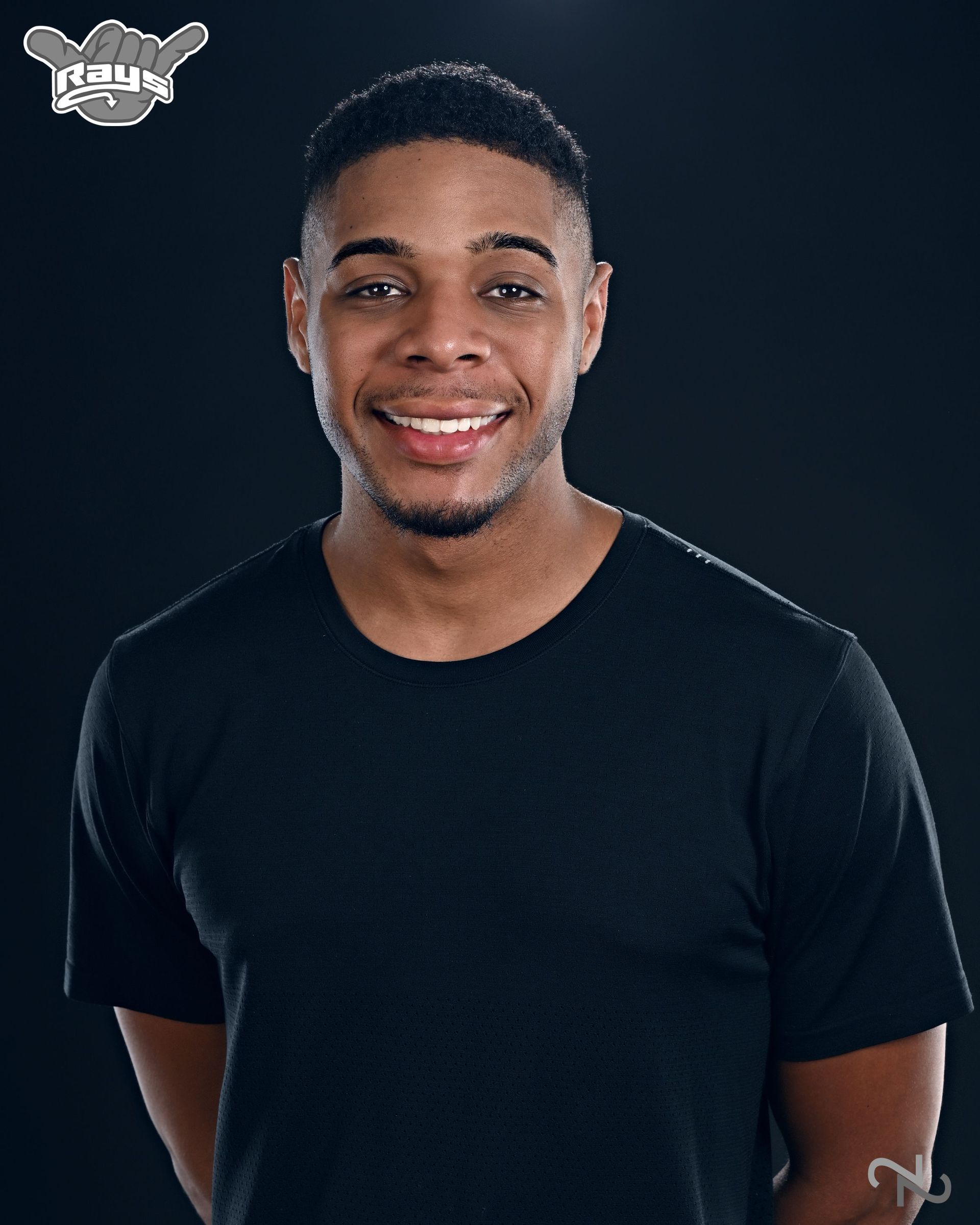 A man in a black shirt is smiling for the camera