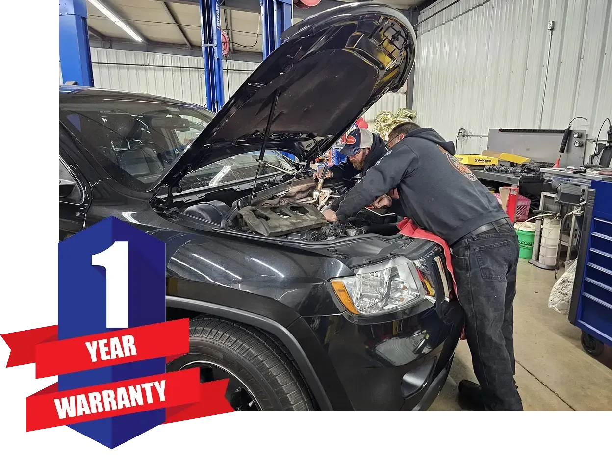 Two people are working on a black jeep in a garage | Guaranteed Auto Repair