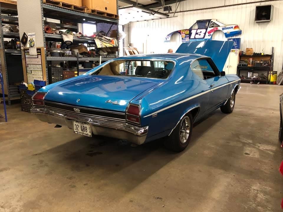 A blue car with the hood up is parked in a garage | Guaranteed Auto Repair