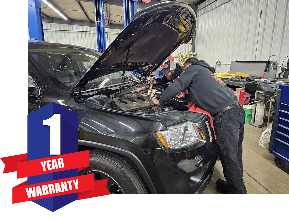 Two people are working on a black jeep in a garage | Guaranteed Auto Repair