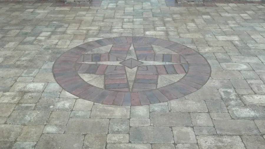 There is a circular design in the middle of the pavement.