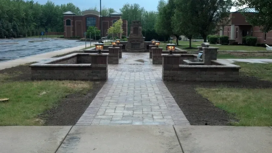 A brick walkway leading to a fireplace in a park