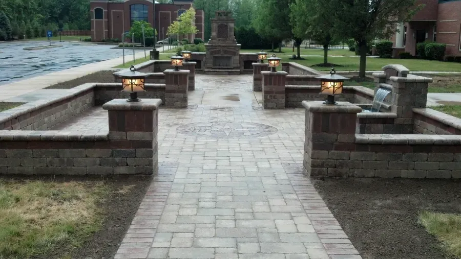 A brick walkway leading to a fireplace in a park.