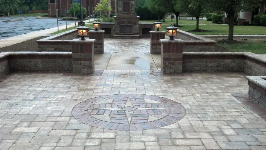 A brick patio with a fireplace and a circular design on it.