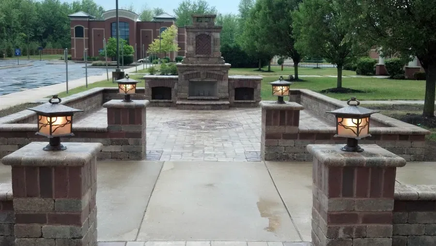 A brick walkway leading to a fireplace in a park.